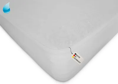 A white mattress protector is shown from a diagonal angle, with a small tag indicating it is made in Germany and a water droplet icon in the top left corner.