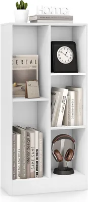 A white, multi-compartment bookshelf filled with books, a clock, and headphones.