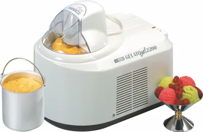 A white NEMOX Gelato Chef 2200 i-Green ice cream maker is shown with a metal container of ice cream, and a bowl of colorful ice cream scoops.