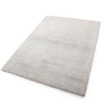 A beige rug is shown from a diagonal angle on a white background.