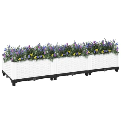 A long, white, modular planter box filled with purple and yellow flowers, set against a white background.