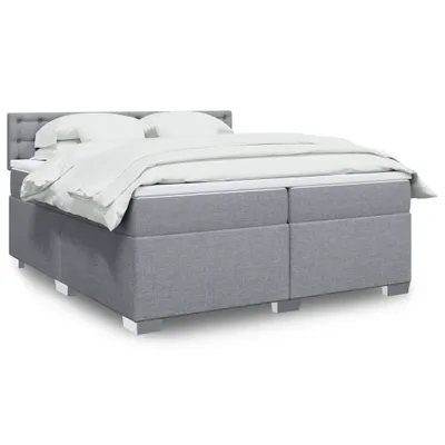 A studio shot of a bed with white bedding.