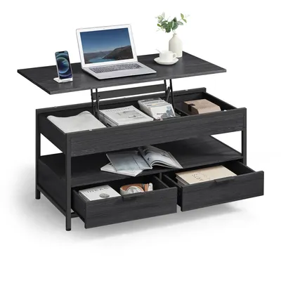A dark gray lift-top coffee table with multiple storage compartments, a laptop, a phone, a cup, and a vase with flowers on top.