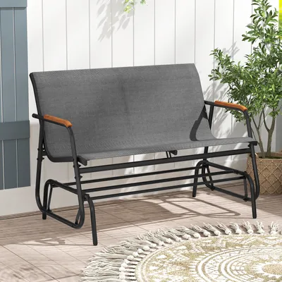 A gray fabric garden bench with black metal frame and wooden armrests sits on a wooden deck.