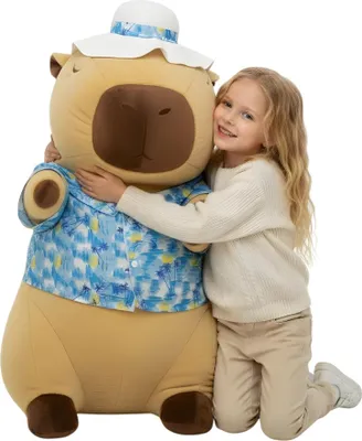 A young girl hugging a large capybara plush toy.