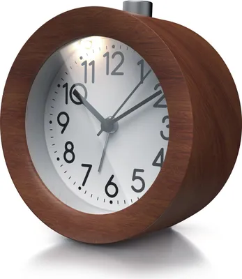 A close-up, studio shot of a round, analog alarm clock with a wooden frame and a white face.