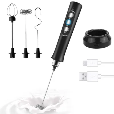 A handheld electric frother with multiple attachments, charging cables, and a charging stand, shown being used in milk.