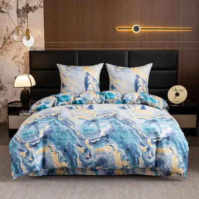 A bed with marble-patterned bedding and pillows, set against a headboard and bedside tables with lamps and a clock.