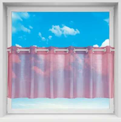 A close-up view of a window with a sheer curtain hanging across the lower half, revealing a blue sky with clouds behind it.