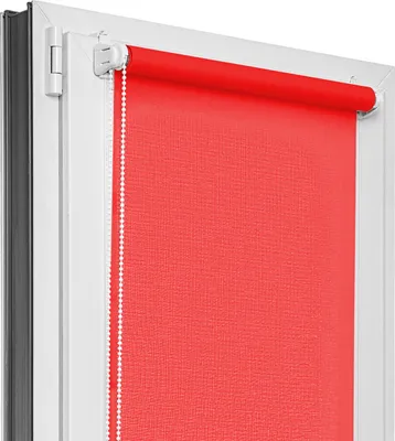 A red roller blind installed in a white window frame.