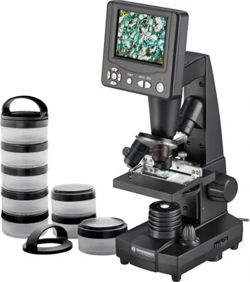 A digital microscope with accessories, including storage containers, is displayed against a white background.