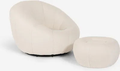A white bouclé armchair and matching ottoman are shown against a white background.