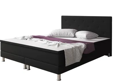 A black boxspring bed with a tufted headboard, white bedding, and a purple throw blanket, shown against a white background.