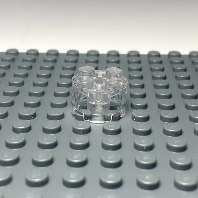 A transparent LEGO brick is placed on a gray LEGO baseplate.