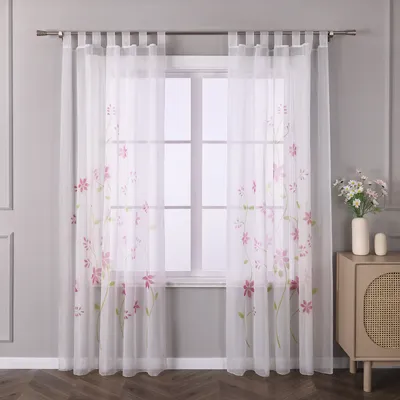A window with sheer curtains featuring a floral pattern.