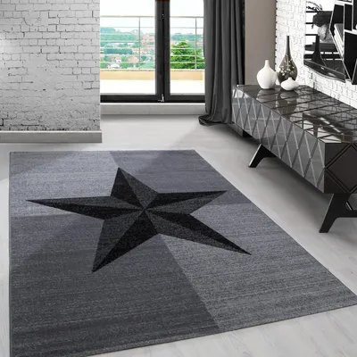 A modern living room with a rug featuring a star pattern, a console table, and a large window.