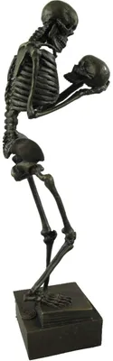 A dark-colored skeleton figurine holding a skull.
