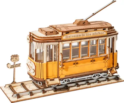 A 3D wooden model of a tram on a track with a station sign.