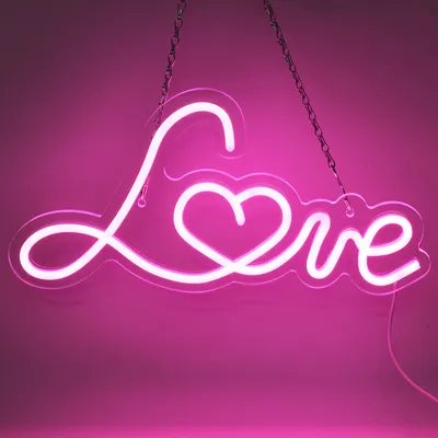A pink neon sign shaped like the word "Love" with a heart in the middle, hanging from chains against a pink background.
