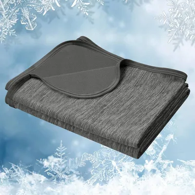 A folded gray blanket is shown against a background of snowflakes and a light blue sky.
