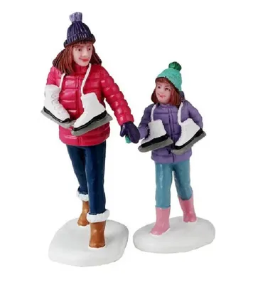 Mutter und ihre Tochter die sich auf einen Eislaufausflug vorbereiten.