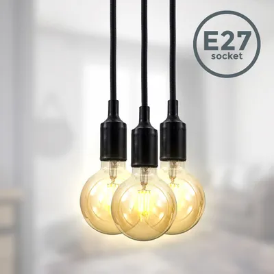 Three vintage-style pendant lights with exposed Edison bulbs hang against a blurred background.