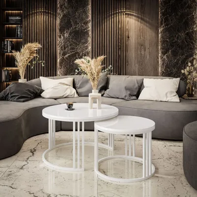 A modern living room with a curved sofa, coffee tables, and decorative elements.