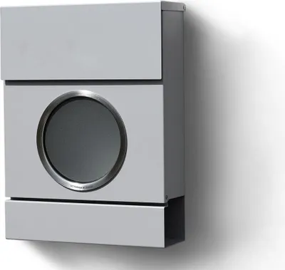 A modern, light gray mailbox mounted on a white wall, casting a shadow.