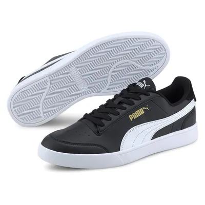 A pair of black Puma sneakers with white accents and gold branding, shown from a slightly elevated side angle with the sole of one shoe visible.