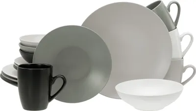 A collection of stoneware dishes and mugs, including plates, bowls, and cups, arranged in a group.