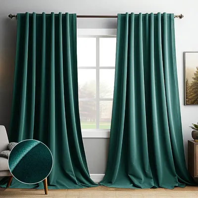 A room with dark green velvet curtains hanging over a window, with a chair and a small table visible.