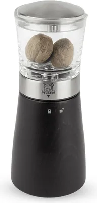 A nutmeg grinder with whole nutmegs inside.