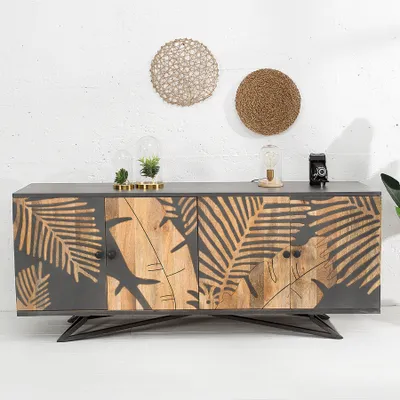 A sideboard with a tropical leaf design on a white wall.