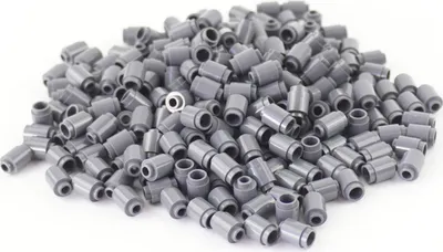 A pile of small, round, dark gray LEGO bricks on a white background.