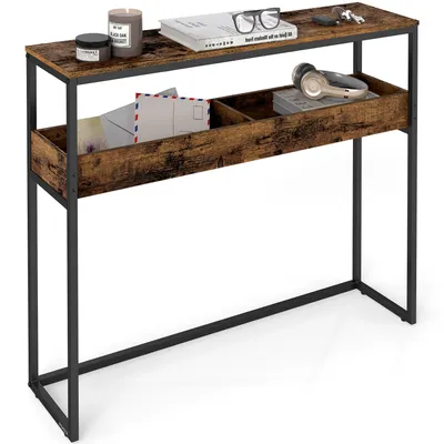 A narrow console table with a rustic wood finish and black metal frame, featuring two shelves with divided compartments. It is styled with a book, glasses, keys, a candle, a jar, and envelopes.