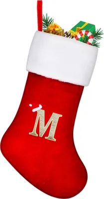 A red Christmas stocking with a white trim, decorated with the letter 'M' and filled with small gifts and pine sprigs.