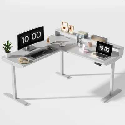 A white L-shaped standing desk with computer monitors, a laptop, and office accessories.
