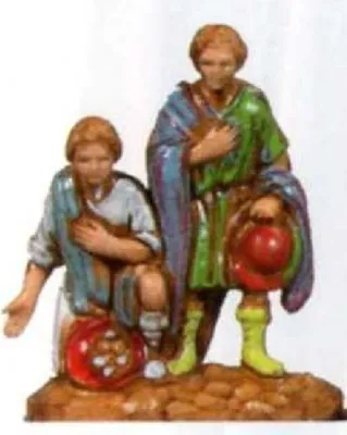 Zwei kleine Figuren, die wahrscheinlich Teil einer Weihnachtskrippe sind.
