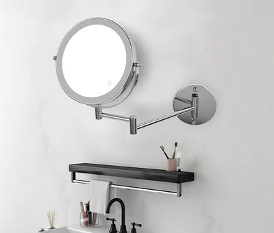 A bathroom vanity area with a wall-mounted LED makeup mirror, a shelf with toiletries, and a faucet.