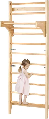 A young child is climbing on a wooden wall-mounted gym.