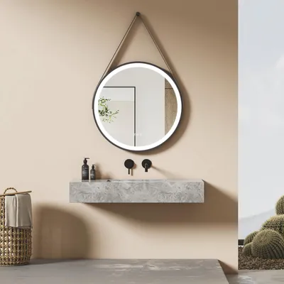 A modern bathroom with a round LED mirror, a floating marble sink, and a woven basket with a towel.