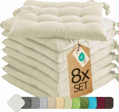 A stack of cream-colored seat cushions with a tag attached.