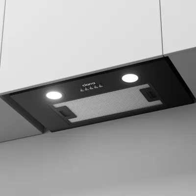 A black under-cabinet range hood with integrated lights and controls, mounted beneath white kitchen cabinets.