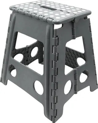 A gray folding step stool with white polka dots on the top surface, shown from a three-quarter angle.
