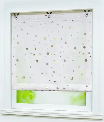 A white roller blind with gold polka dots is installed on a window.