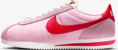 A side view of a pink Nike Cortez sneaker.