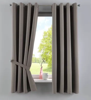 A pair of taupe curtains tied back with a fabric band, shown in front of a window with a view of trees and a grassy field. A pink vase and a white pot are on the windowsill.