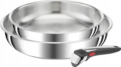 Two stainless steel pans stacked on top of each other with a detachable handle in the foreground.