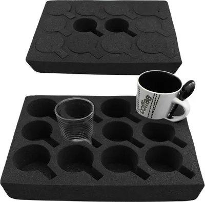 Two black foam inserts with multiple circular cutouts designed to hold cups or glasses. The bottom insert shows a clear glass and a white mug with a spoon.