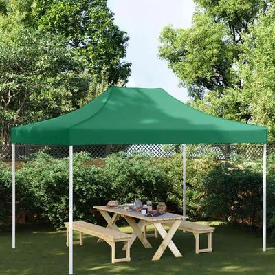A green party tent set up in a garden with a wooden picnic table and benches underneath.